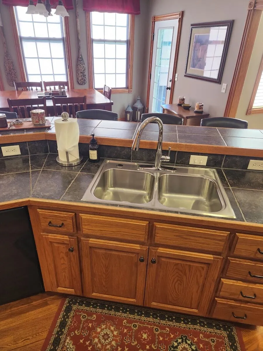 Kitchen sink and oak lower cabinets polished, looking into the dining area