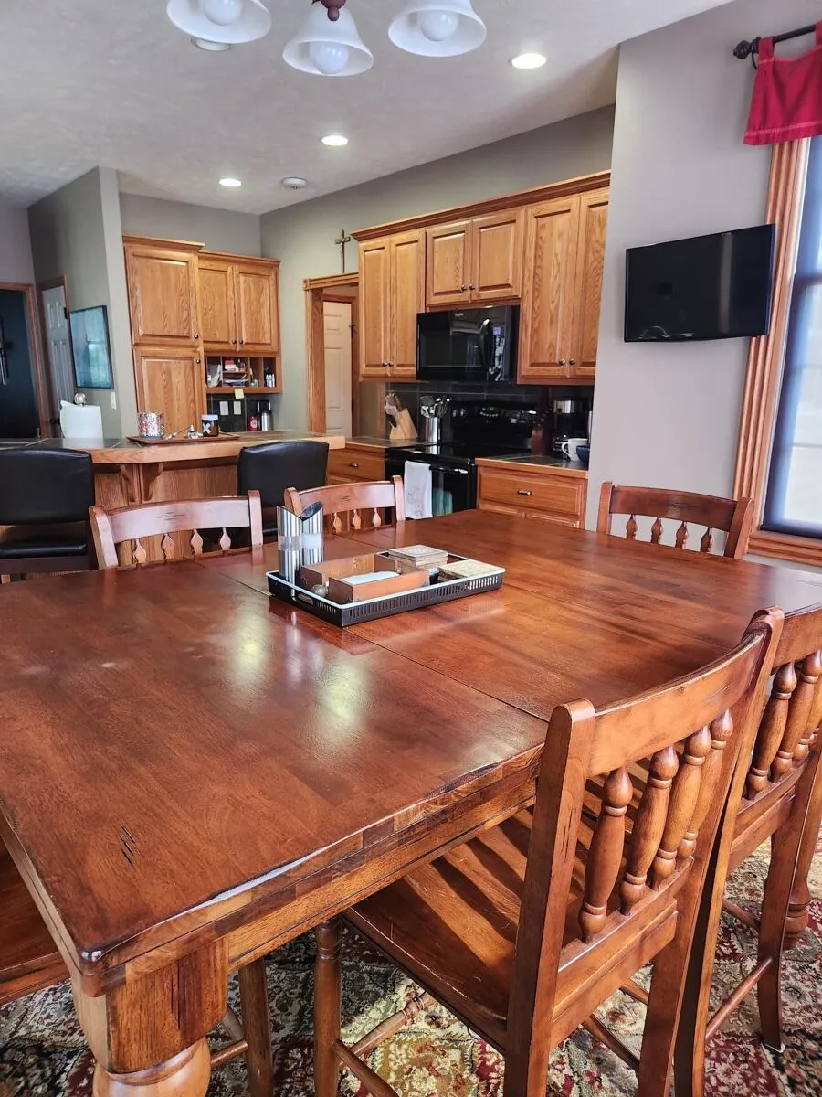 Wood dining table polished, with the open oak kitchen in the background